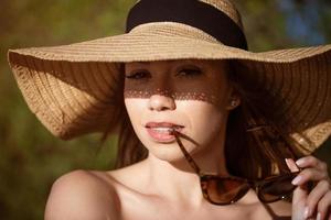 Nahansicht Porträt von ein Frau tragen ein Sonne Hut foto