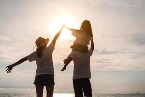 glücklich asiatisch Familie genießen das Meer Strand beim bestehend aus Vater, Mutter und Tochter haben Spaß spielen Strand im Sommer- Ferien auf das Ozean Strand. glücklich Familie mit Urlaube Zeit Lebensstil Konzept. foto