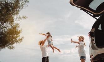 glückliche familie mit autoreise road trip. sommerferien im auto im sonnenuntergang, vater, mutter und tochter glücklich reisen genießen zusammen fahren in den ferien, menschen lebensstil fahren mit dem auto. foto