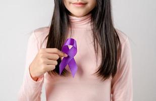 Frau Hände halten lila Band, Alzheimer Krankheit, Bauchspeicheldrüse Krebs, Epilepsie Bewusstsein, Welt Krebs Tag auf ein lila farbig Hintergrund, Welt Krebs Tag Konzept foto