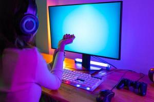 Handgelenk Schmerzen Konzept. Spieler und E-Sport online von asiatisch Frau spielen online Computer Video Spiel mit Beleuchtung Wirkung, Übertragung Streaming Leben beim heim. ihr verwenden ihr Handgelenk zum ein lange Zeit. foto