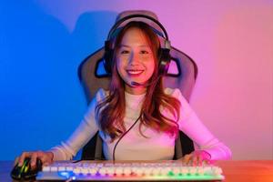 Spieler und E-Sport online von asiatisch Frau spielen online Computer Video Spiel mit Beleuchtung Wirkung, Übertragung Streaming Leben beim heim. Spieler und E-Sport online Spielen Technologie Meisterschaft Turnier. foto