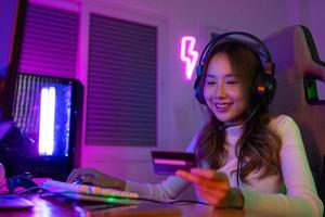 oben oben online Spiel mit Anerkennung Karte Konzept. Spieler und E-Sport online von asiatisch Frau spielen online Computer Video Spiel mit Beleuchtung Wirkung, Übertragung Streaming Leben beim heim. Spieler und E-Sport Spielen foto