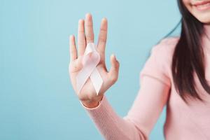 glücklich Frau zeigen Rosa Band, Brust Krebs Bewusstsein, Welt Krebs Tag, National Krebs Überlebende Tag im Februar Konzept. foto