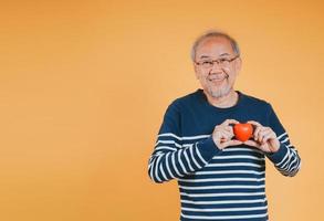 Senior männlich halten Herz Liebe Emotion Versicherung Konzept auf Farbe Hintergrund. foto