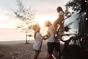 Familie mit Auto Reise Fahren Straße Ausflug Sommer- Ferien im Auto im das Sonnenuntergang, Papa, Mama und Tochter glücklich Reisen genießen Ferien und Entspannung zusammen erhalten das Atmosphäre und gehen zu Ziel foto