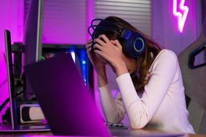 Spiel Über Verlust passen. asiatisch Spiel mit Kopfhörer spielen online Video Spiel auf Computer pc Neon- Licht beim Zuhause Gefühl traurig enttäuscht Über Spiel verlieren, Turnier Spieler E-Sport foto