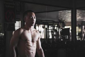 sexy Körper von muskulös jung Soldat asiatisch Mann im Fitnessstudio. Konzept von Gesundheit Pflege, Übung Fitness, stark Muskel Masse, Körper Erweiterung, Fett die Ermäßigung zum Herren Gesundheit Ergänzung Produkt Präsentation. foto