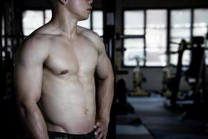 sexy Körper von muskulös jung Soldat asiatisch Mann im Fitnessstudio. Konzept von Gesundheit Pflege, Übung Fitness, stark Muskel Masse, Körper Erweiterung, Fett die Ermäßigung zum Herren Gesundheit Ergänzung Produkt Präsentation. foto