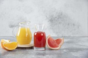 zwei Gläser Grapefruit und Orangensaft auf einem Steinhintergrund foto