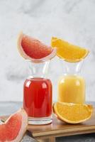 zwei Gläser Grapefruit und Orangensaft auf einem Steinhintergrund foto