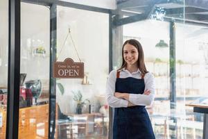 Porträt von ein Frau, ein Kaffee Geschäft Geschäft Inhaber lächelnd schön und Öffnung ein Kaffee Geschäft Das ist ihr besitzen Geschäft, klein Geschäft Konzept. foto