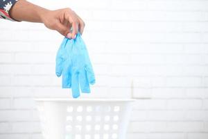 Entsorgung eines gebrauchten blauen Handschuhs foto