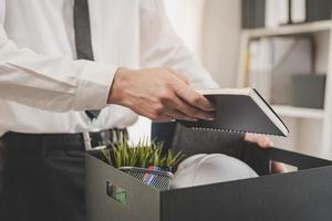 arbeitslos, ziemlich Arbeit. verzweifelt kaukasisch jung Geschäftsmann zurücktreten von Unternehmen, Hand halten Sachen in das Karton, Verpackung Besitz, entlassen oder Ändern arbeiten. Kündigung, Anstellung Konzept foto