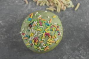 ein grüner süßer Donut mit Streuseln foto