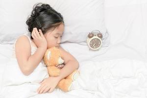 süß Mädchen Schlaf und Umarmung trddy Bär Puppe foto