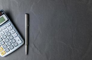 Büro schwarz Stein Schreibtisch Tabelle mit Taschenrechner und Stift foto