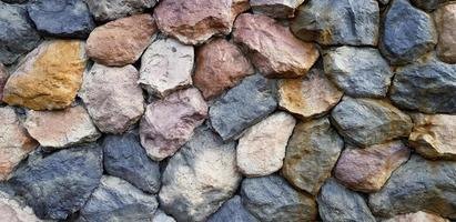 bunt von groß Felsen oder Stein Mauer zum Hintergrund. Gruppe von Objekt, Muster Hintergrund und geknackt Konzept foto