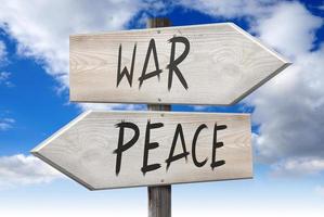 Frieden, Krieg - - hölzern Wegweiser mit zwei Pfeile und wolkig Himmel im Hintergrund foto
