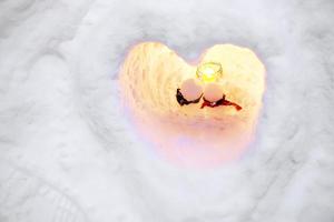 Nahansicht Schneemann Liebhaber im ein Herz Form Schnee Kerze und Schnee Mauer Hintergrund. Schnee Kerzen sind Aktivitäten von das otaru Schnee Licht Pfad Festival beim otaru, Hokkaido Präfektur, Japan. foto