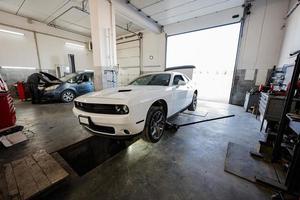 Muscle-Car an der Service-Reparaturstation. bockt das Auto auf, um das Chassis zu diagnostizieren. foto