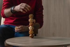 männlich Hände stellen zusammen anders zahlen von hölzern Polyeder, Öko Spiele zum Erwachsene und Kinder, Anti-Stress Spielzeuge gemacht von natürlich Holz foto