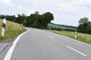 kurvig Land Straße beim Grün Korn Felder foto