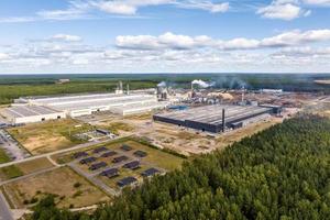 Antenne Panorama- Aussicht von Stadt mit ein enorm Fabrik mit Rauchen Schornsteine im das Hintergrund foto