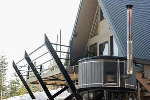 hölzern Dreieck Land winzig Kabine Haus mit heiß Wanne Spa im Berge. Seele Wochenenden. foto