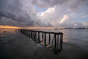 hölzern Brücke beim Meer mit Penang Brücke foto