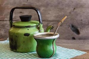 Kamerad und Wasserkocher, traditionell Argentinien Yerba Kamerad Infusion, auf rustikal hölzern Hintergrund foto