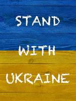 Slogan Stand mit Ukraine auf gemalt ukrainisch Flagge foto