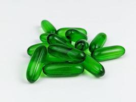 Grün transparent Kapsel Tabletten von Vitamin e isoliert auf Weiß Hintergrund foto