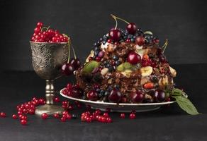 ein luxuriös Kuchen mit Früchte und Beeren im ein Glas Kelch auf ein dunkel Hintergrund. foto