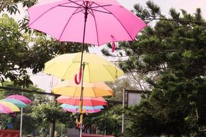 bunt Regenschirme hängend über Straße von das Park. foto