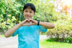 Porträt von glücklich Kinder Hände Geste im Herz gestalten zeigen Liebe und Freundlichkeit. Konzept von Liebe, Welt Herz Tag. foto