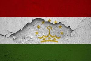 Erdbeben im Tadschikistan, Flagge Tadschikistan auf ein Mauer mit Risse von ein Erdbeben foto
