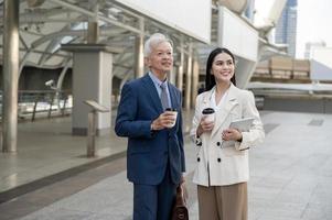 asiatisch Senior reifen Mitte alt Geschäftsmann und jung Geschäftsfrau haben ein Diskussion und Kaffee im modern Stadt foto