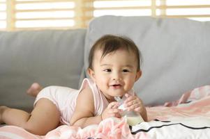 ein Baby Mädchen ist Trinken Milch Flasche, Familie, Kind, Kindheit und Elternschaft Konzept foto