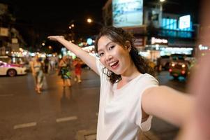 schön jung asiatisch Tourist Frau auf Ferien Besichtigung und erkunden beim khao san Straße beim Nacht im Bangkok Stadt, Thailand, Ferien und Reisen Konzept foto