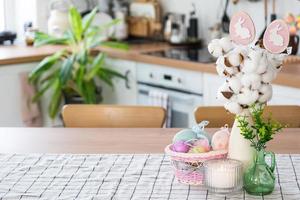 Ostern Dekoration von bunt Eier im ein Korb und ein Hase auf das Küche Tabelle im ein rustikal Stil. festlich Innere von ein Land Haus foto