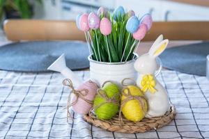 Ostern Dekoration von bunt Eier im ein Korb und ein Hase auf das Küche Tabelle im ein rustikal Stil. festlich Innere von ein Land Haus foto