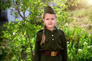 Porträt von ein Mädchen im Uniform auf ein Grün Hintergrund. Sieg Tag . foto