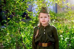 Porträt von ein Mädchen im Uniform auf ein Grün Hintergrund. Sieg Tag foto