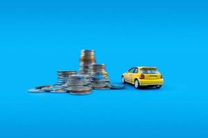 ein Gelb Spielzeug Auto und Stapel von Münzen. Konzept von finanziell Planung zum Kauf ein Wagen. foto