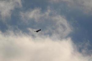 klein Flugzeug fliegend im das Himmel gegen dunkel Wolken foto