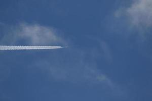 ein Flugzeug und Kondensstreifen am Himmel foto