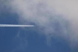 ein Flugzeug und Kondensstreifen am Himmel foto