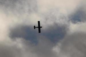 klein Flugzeug fliegend im das Himmel gegen dunkel Wolken foto