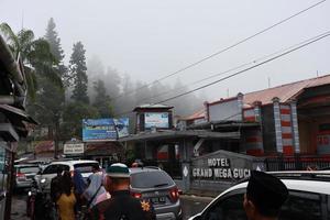 tegal, Januar 2023. Gruppe Foto auf das Weg zu Guci Tourist Stelle. mit das Dichte von Besucher, beschäftigt Parkplatz Fahrzeuge und verschiedene Arten von Verkäufer auf das Seite von das Straße.